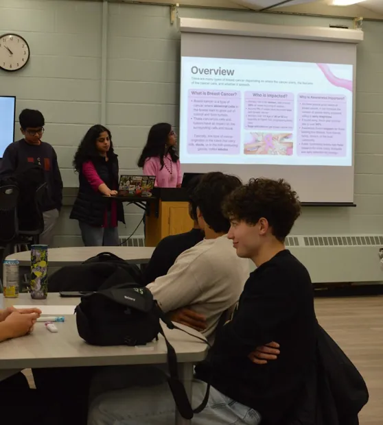 Students listening to the opening presentation at FHI's breast cancer awareness event
